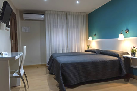 a room for two people with a table and tv in the verona hostel