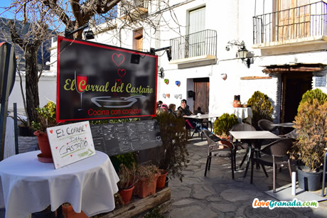 exterior terrace with tables and people eating in the corral del castano restaurant