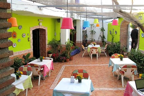 green patio with tables in hostel la herradura