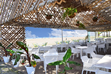 tables with chairs on the beach with the sea in the background of bambu beach restaurant