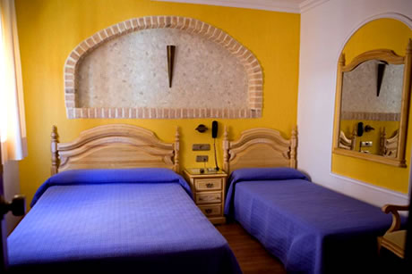 double bed with yellow background wall in campana hostel