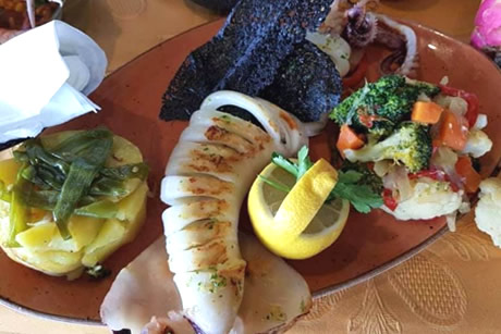 grilled squids on a wooden ship in casa emilio restautant