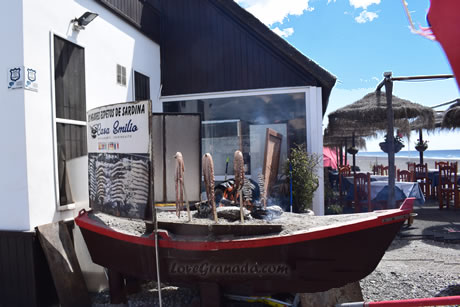 wooden boat with grilled sardins in salomar beach