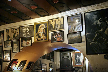 a wall full of pictures of the artist in eshavira pub