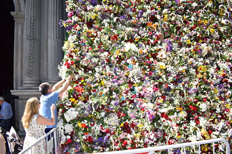 people putting fowers to the virgen angustias basilica facade