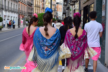 girls walking in flamenco dresses on the street