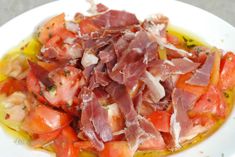 a plate of food parmaham with tomatoes
